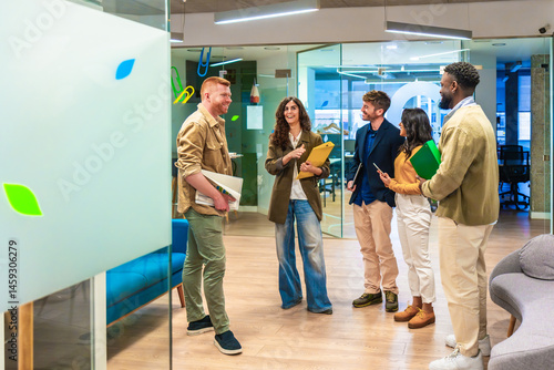 Startup team discussing green business strategy in modern office