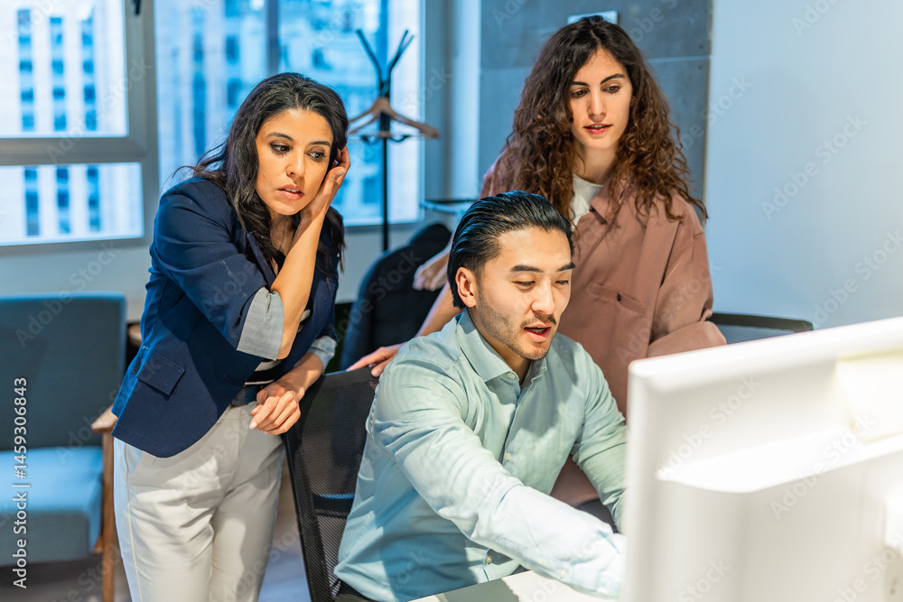 Business team analyzing data on computer in modern office