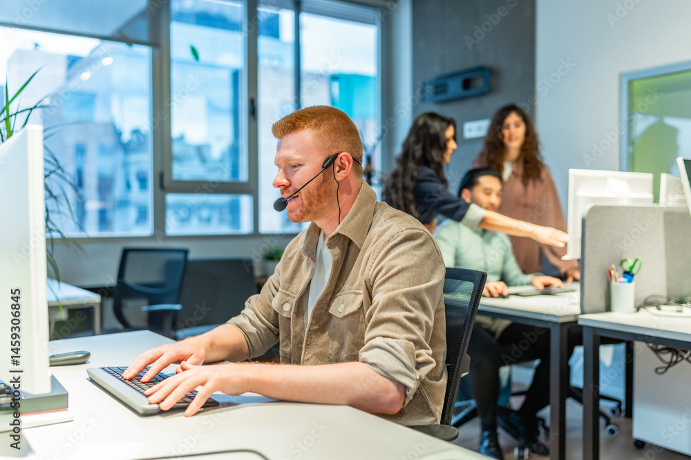 Operator with headset typing on keyboard in busy office