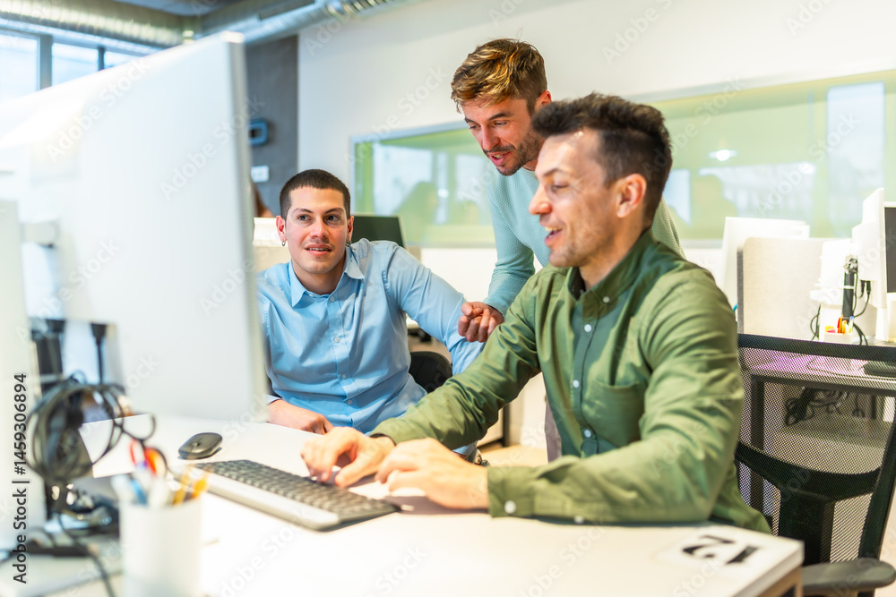 Software developers working together on a computer in office