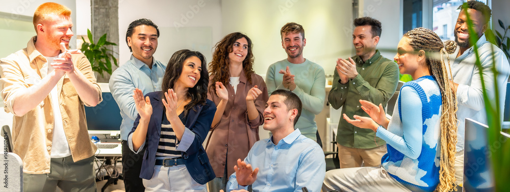 Diverse business team clapping and celebrating success in modern office