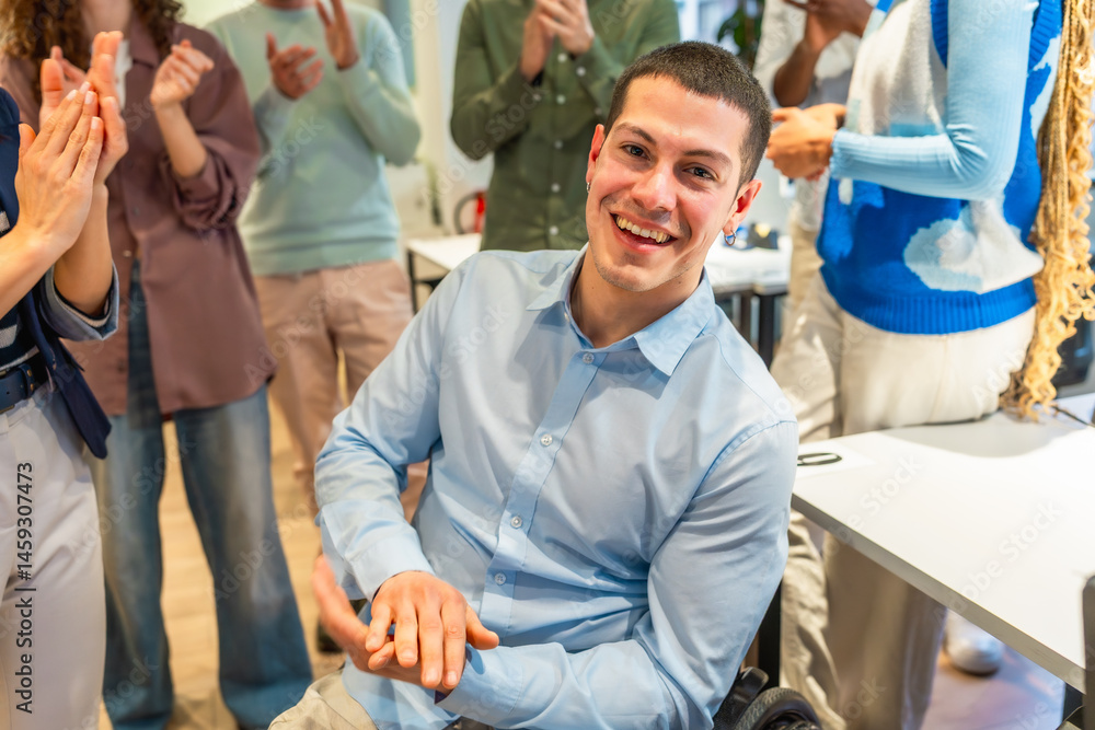 Happy disabled manager receiving clapping from coworkers in modern office