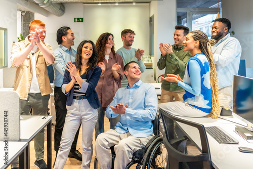 Картината върху платно Diverse business team applauding colleague in wheelchair in modern office