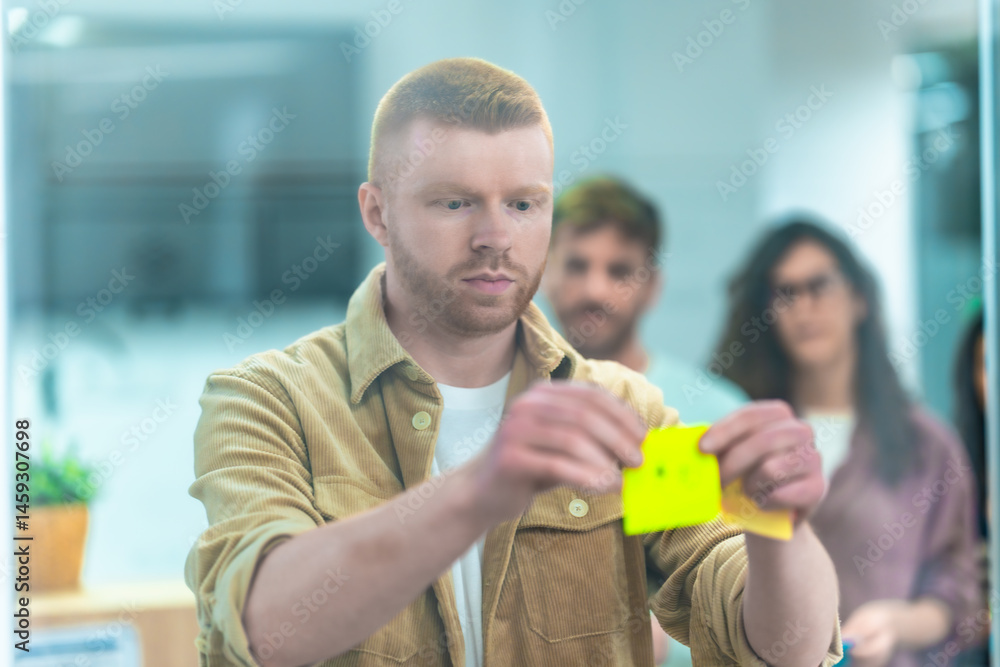 Focused office worker using sticky notes during brainstorming session