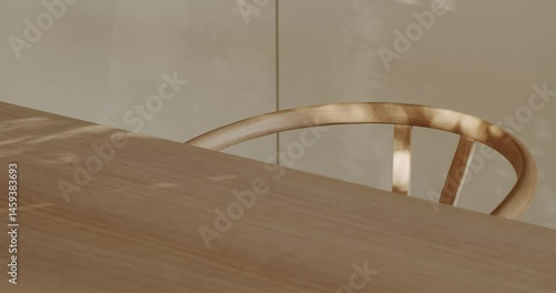 Sunlight streams through a window, casting playful shadows on a modern wooden table and the curved back of a matching chair. interior design, furniture, or lifestyle projects.