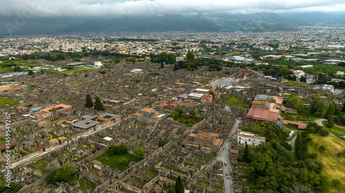 Obraz na płótnie Aerial view of the ruins and remains in the archaeological park of Pompeii, located in the province of Naples, Campania, Italy. It was an ancient Roman town. In background there is the modern city. w salonie