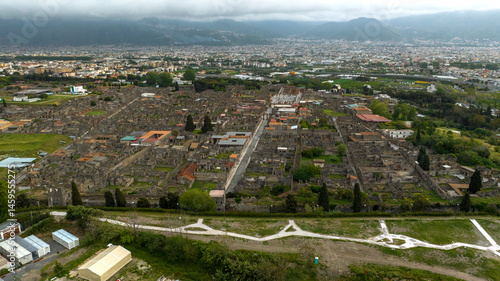 Obraz na płótnie Aerial view of the ruins and remains in the archaeological park of Pompeii, located in the province of Naples, Campania, Italy. It was an ancient Roman town. In background there is the modern city. w salonie