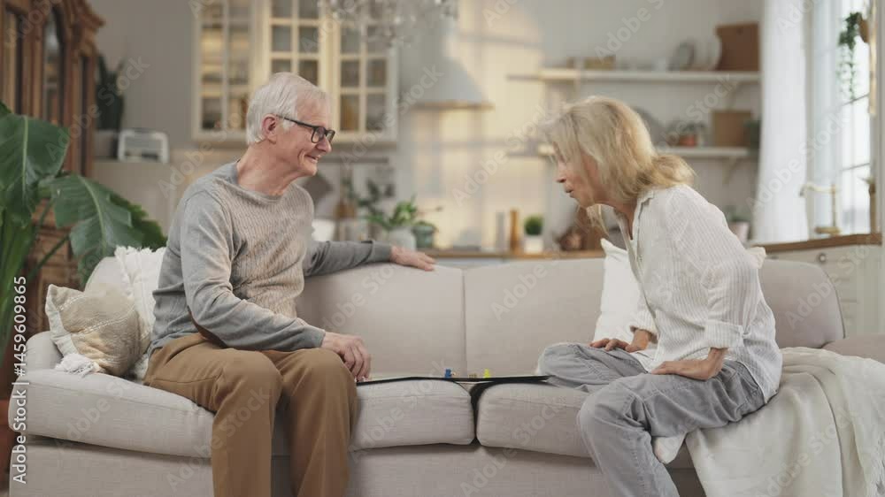 Married couple playing board games at home, happy spouses spending time together . Joyful elderly man and woman sitting together on couch, leisure and entertainment, cheerful grandpa and grandpa Married couple playing board games at home, happy spouses spending time together . Joyful elderly man and woman sitting together on couch, leisure and entertainment, cheerful grandpa and grandpa