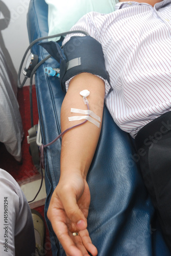 Close up image of young asian man's arm while donating blood.