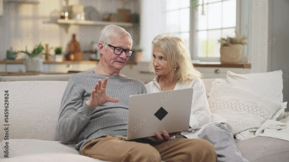 Joyful old spouses chatting online with friends, using laptop for video call. Portrait of happy married couple in old age, smiling and laughing people, good mood, positive emotions from communication Joyful old spouses chatting online with friends, using laptop for video call. Portrait of happy married couple in old age, smiling and laughing people, good mood, positive emotions from communication