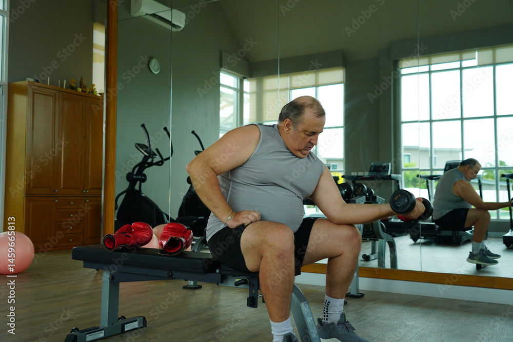Elderly Caucasian man with a fat belly wearing gym clothes lifting dumbbells doing exercises to build muscle for health and lose weight in a fitness center Health and wellness concept