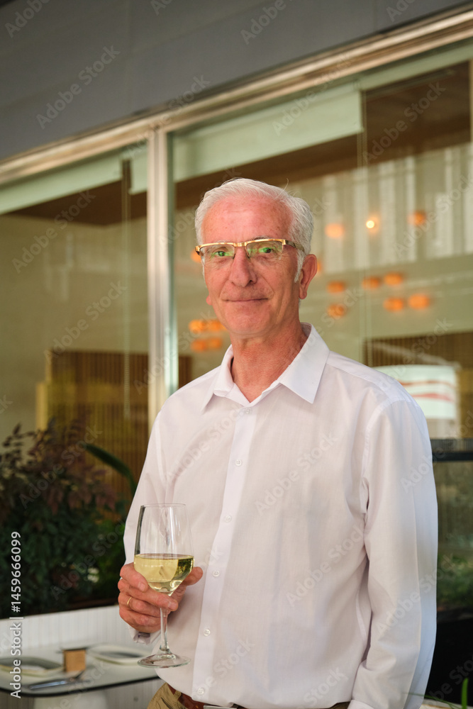Senior businessman enjoying white wine during happy hour at restaurant