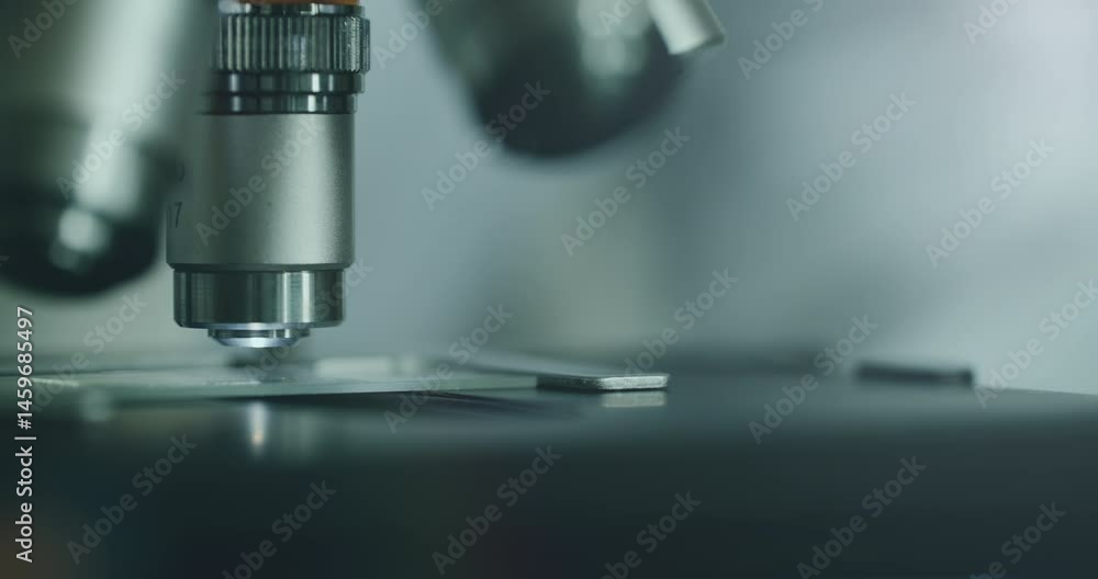 Close-up of biologist gloved hands using microscope in sterile laboratory. Vibrant blue gloves highlight precise scientific work against monochromatic lab backdrop Close-up of biologist gloved hands using microscope in sterile laboratory. Vibrant blue gloves highlight precise scientific work against monochromatic lab backdrop