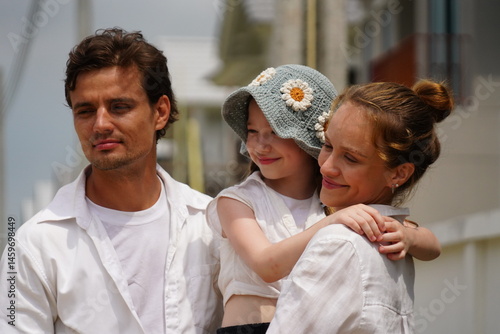 Caucasian family father holding seven year old daughter with mother standing together happily kissing cheek of three new children in housing project planning finance insurance home loan to build futur