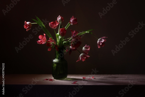 Obraz na płótnie pink tulips in green glass vase on table on dark background w salonie