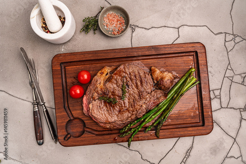 Beef grill steak with green asparagus on a cutting board. Healthy dinner or lunch, top view. High quality photo