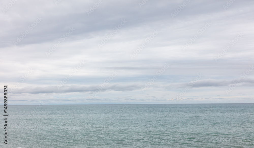 Obraz premium The sky is cloudy and the ocean is calm