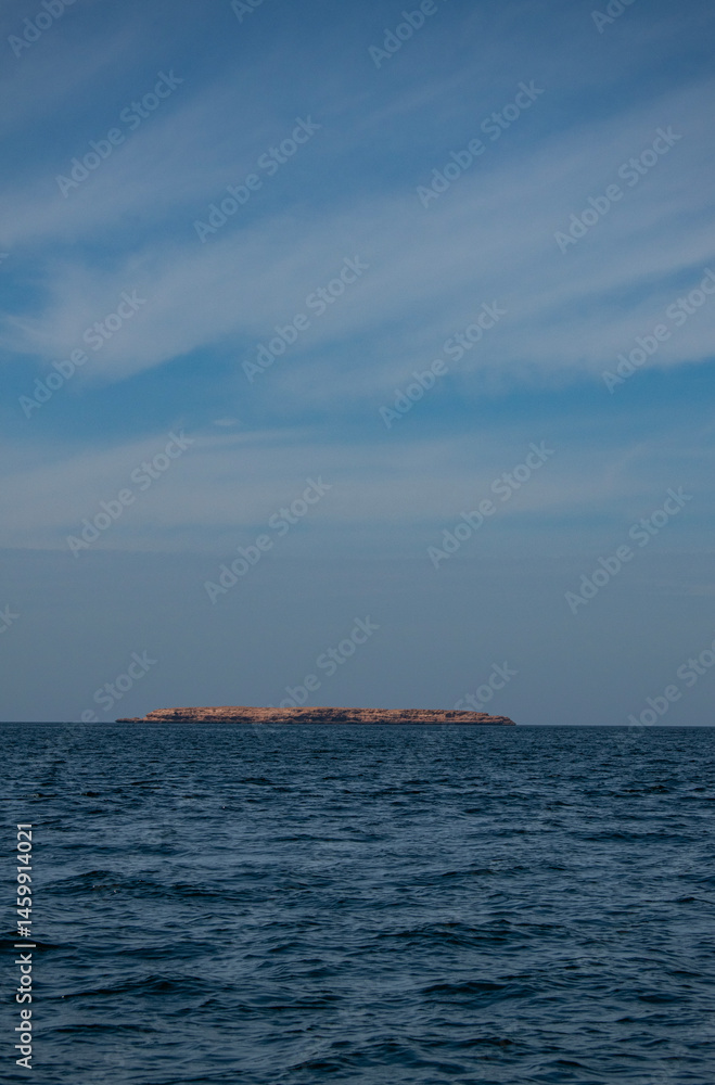 Oman, Middle East: the distant silhouette of one of the of Daymaniyat Islands (Ad Dimaniyat), pristine nature reserve and protected area in the Gulf of Oman, home of sea turtles and migrant birds