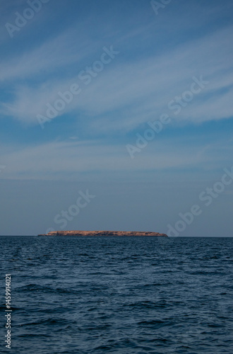 Obraz na płótnie Oman, Middle East: the distant silhouette of one of the of Daymaniyat Islands (Ad Dimaniyat), pristine nature reserve and protected area in the Gulf of Oman, home of sea turtles and migrant birds w salonie