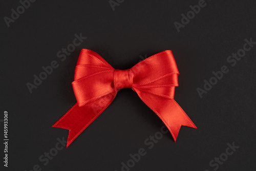Red ribbon and bow on black background