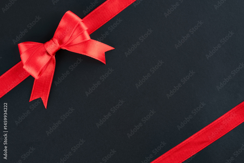 Red ribbon and bow on black background