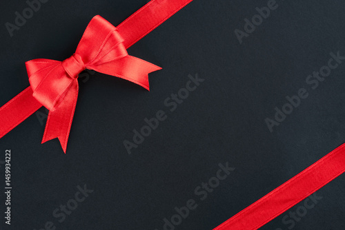 Red ribbon and bow on black background