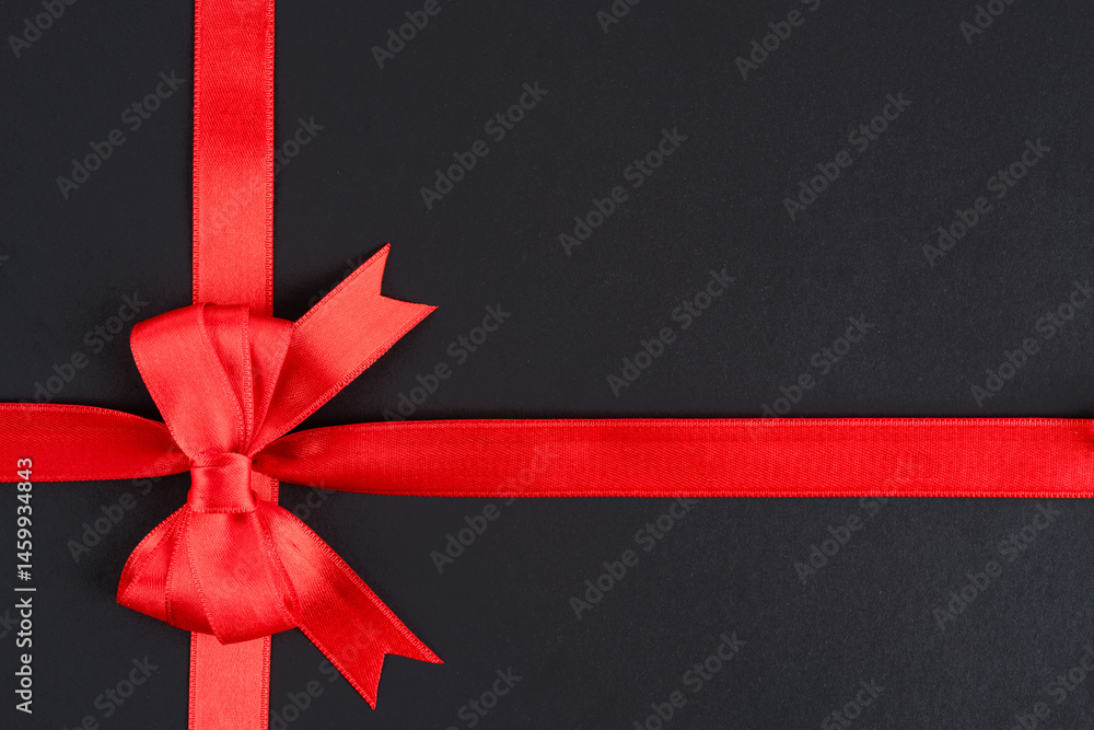 Red ribbon and bow on black background