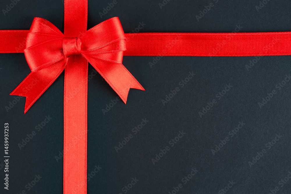 Red ribbon and bow on black background