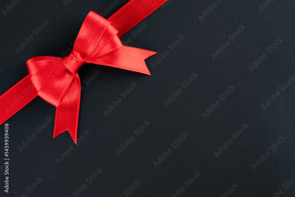 Red ribbon and bow on black background