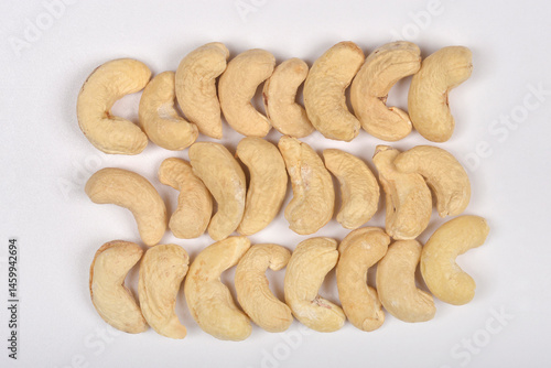 Obraz na płótnie Three horizontal rows of raw cashew nuts are neatly arranged on a light gray surface w salonie