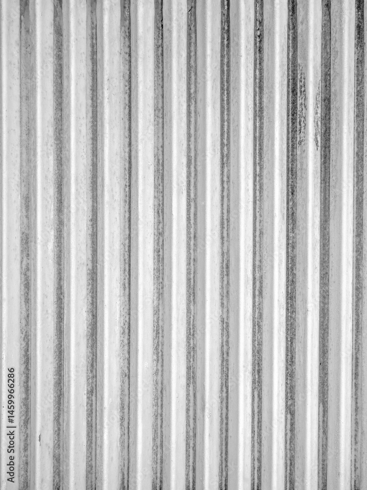 Obraz premium Textured corrugated metal wall with vertical lines in black and white
