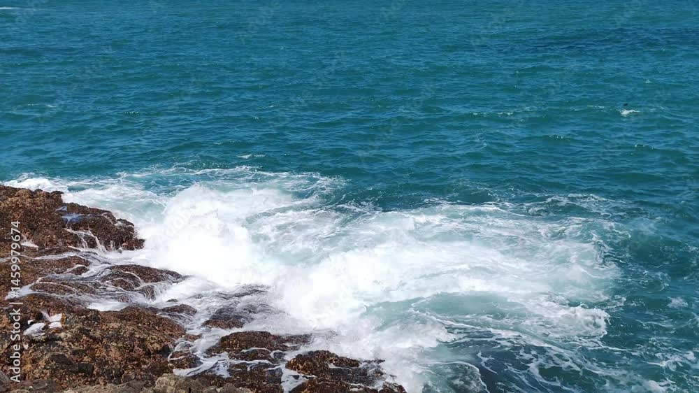 slow motion from the top of the cliff rolling and turning over while chasing the coral on the edge of the beach slow motion from the top of the cliff rolling and turning over while chasing the coral on the edge of the beach