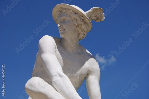 Side profile portrait of a white marble statue of Hermes or Mercury, the herald or messenger of the gods in Greek or Roman mythology, with his winged helmet
