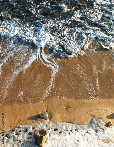 Seascape. Wild beach of Portugal. Waves in motion. Stones washed by water. Abstract background with space for insertion. Wallpaper. Postcard. Poster