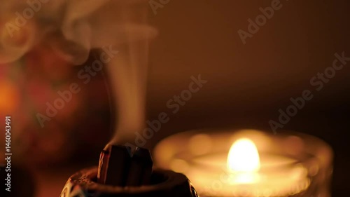 Palo Santo burning with candle in background