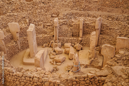 An aerial view showcasing thr ancient archaeological site of gobekli tepe with stone monoliths arranged in a circular pattern, conveying the mysteries of early human construction and culture...
