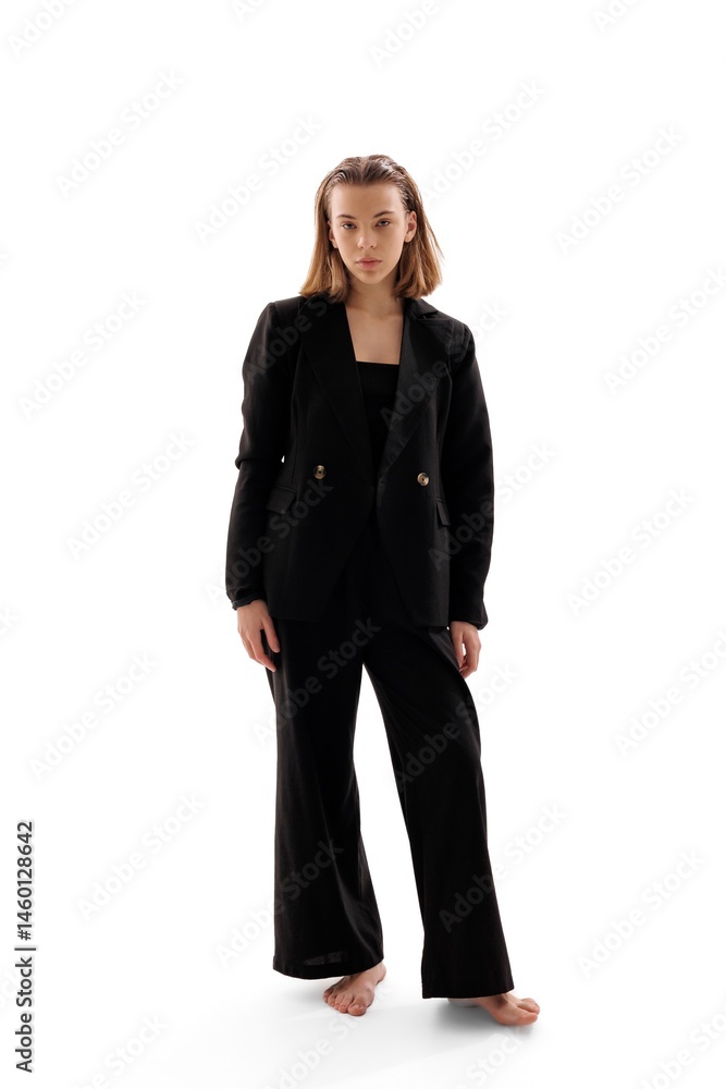Model showcases stylish black suit with elegant simplicity in a studio setting under bright lights Model showcases stylish black suit with elegant simplicity in a studio setting under bright lights