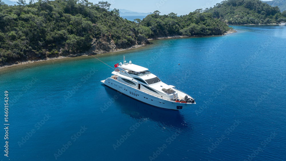Fototapeta premium Luxurious White Yacht Anchored in a Tranquil Bay 