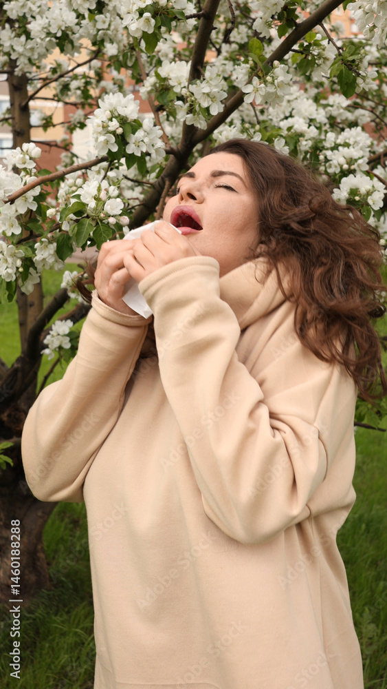 A young woman endures pollen allergies amid blooming spring flowers. She sneezes and uses a paper tissue to ease discomfort, capturing the essence of seasonal struggle and delicate beauty. A young woman endures pollen allergies amid blooming spring flowers. She sneezes and uses a paper tissue to ease discomfort, capturing the essence of seasonal struggle and delicate beauty.