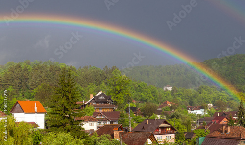 Obraz na płótnie A spectacular landscape with a rainbow over a rural village w salonie