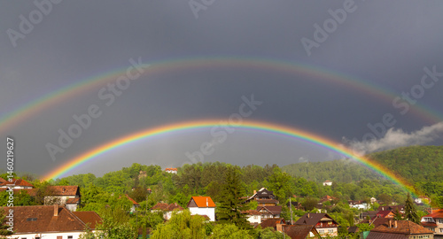 Obraz na płótnie Landscape with a double rainbow above the houses of a village w salonie
