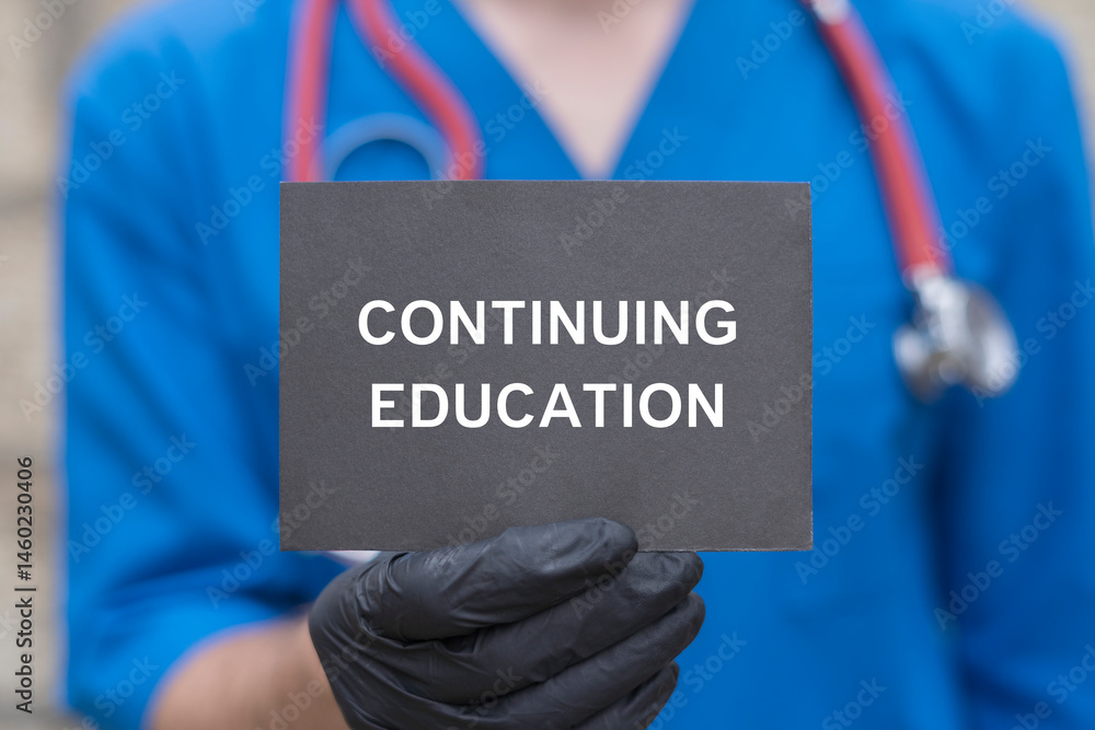 Physician holding black paper card with inscription: CONTINUING EDUCATION. Continuing education and personal development medicine concept. Continuing professional medical education.