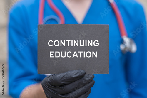 Obraz na płótnie Physician holding black paper card with inscription: CONTINUING EDUCATION. Continuing education and personal development medicine concept. Continuing professional medical education. w salonie