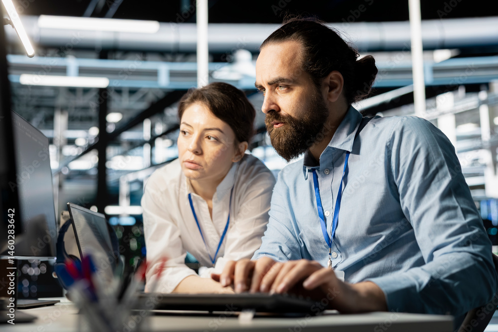Data center coworkers doing brainstorming, running diagnostic scripts on computer, examining hardware. Server room employees talking, working together to evaluate performance metrics