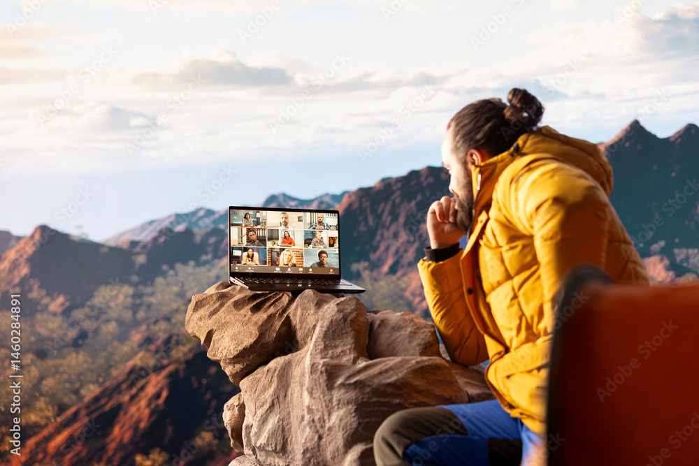 Entrepreneur uses high speed internet connection on mountain top, enjoying the video call with a scenic landscape. Young hiker having an internet dependency and being workaholic.