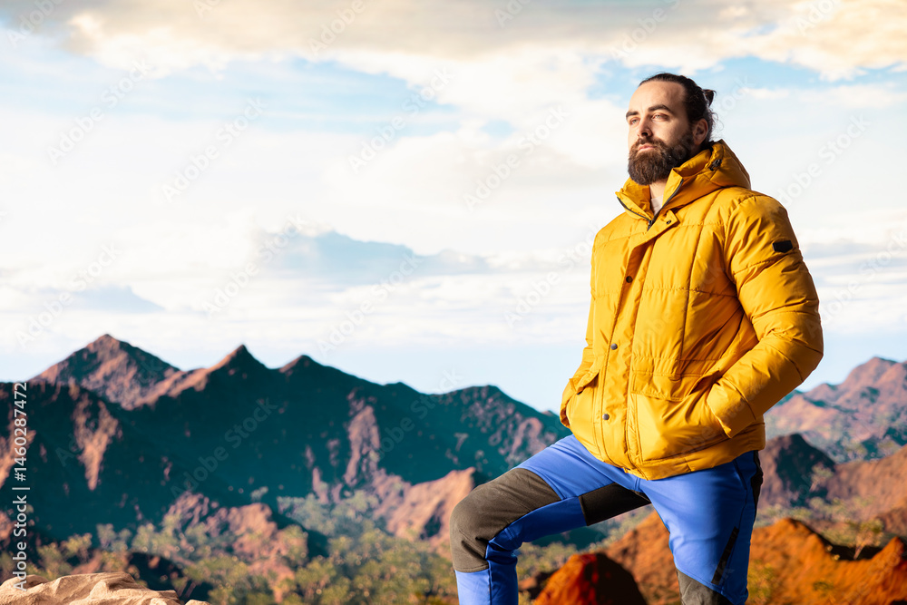 Male explorer embraces the solitude of high altitude wilderness, climbing on top of the mountain for fresh air and a scenic background. Mindfulness and relaxation in the nature.