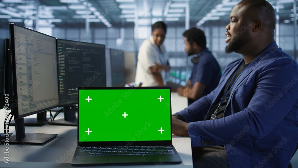 Data center technician using chroma key laptop, maintaining company network infrastructure. Server hub employee ensuring optimal system performance with isolated screen notebook, camera A