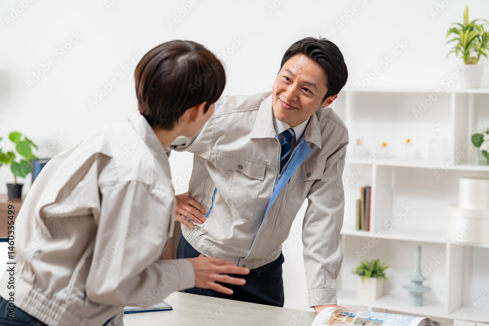 Obraz premium 打ち合わせをする作業着を着た男女