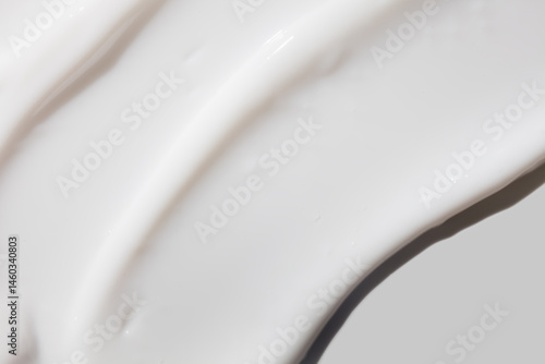 Cosmetic white cream balm or cleansing milk texture smudge isolated on gray background. Skin care beauty product sample swatch