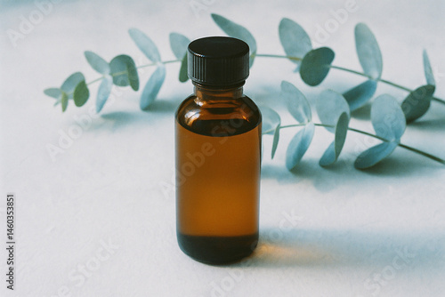 Obraz na płótnie Eucalyptus oil bottle with soothing blue leaves in natural light w salonie
